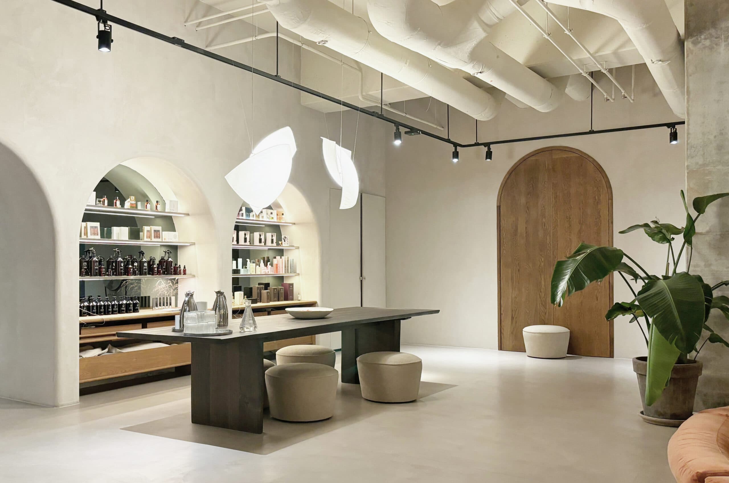 Main wellness space with arched shelving niches, plants and dark oak table