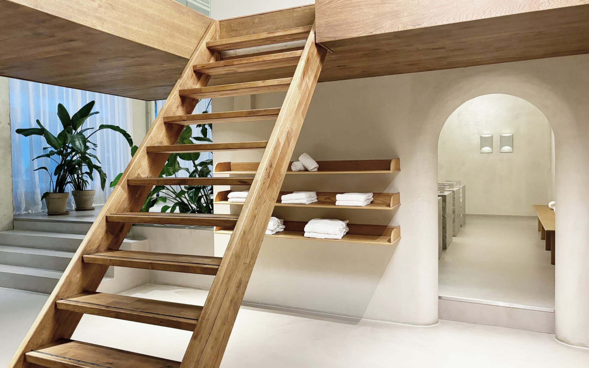 Open oak staircase with white linen towels on built-in shelves