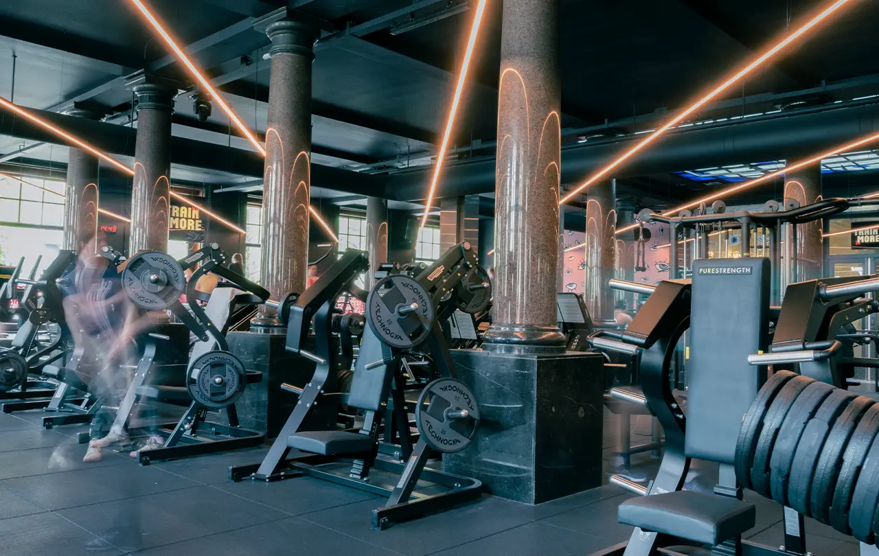 Dark strength training floor with Hammer Strength equipment