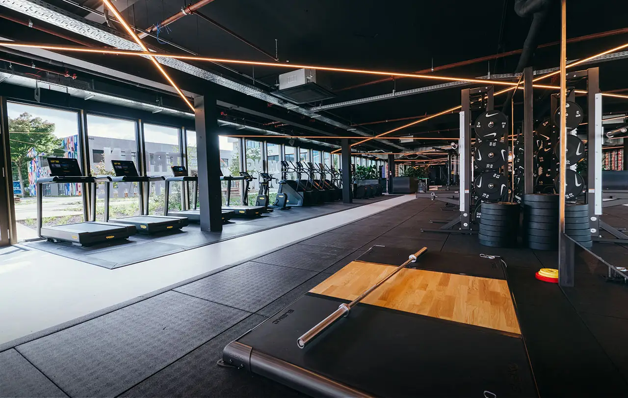 Large open gym floor with treadmills and weight racks