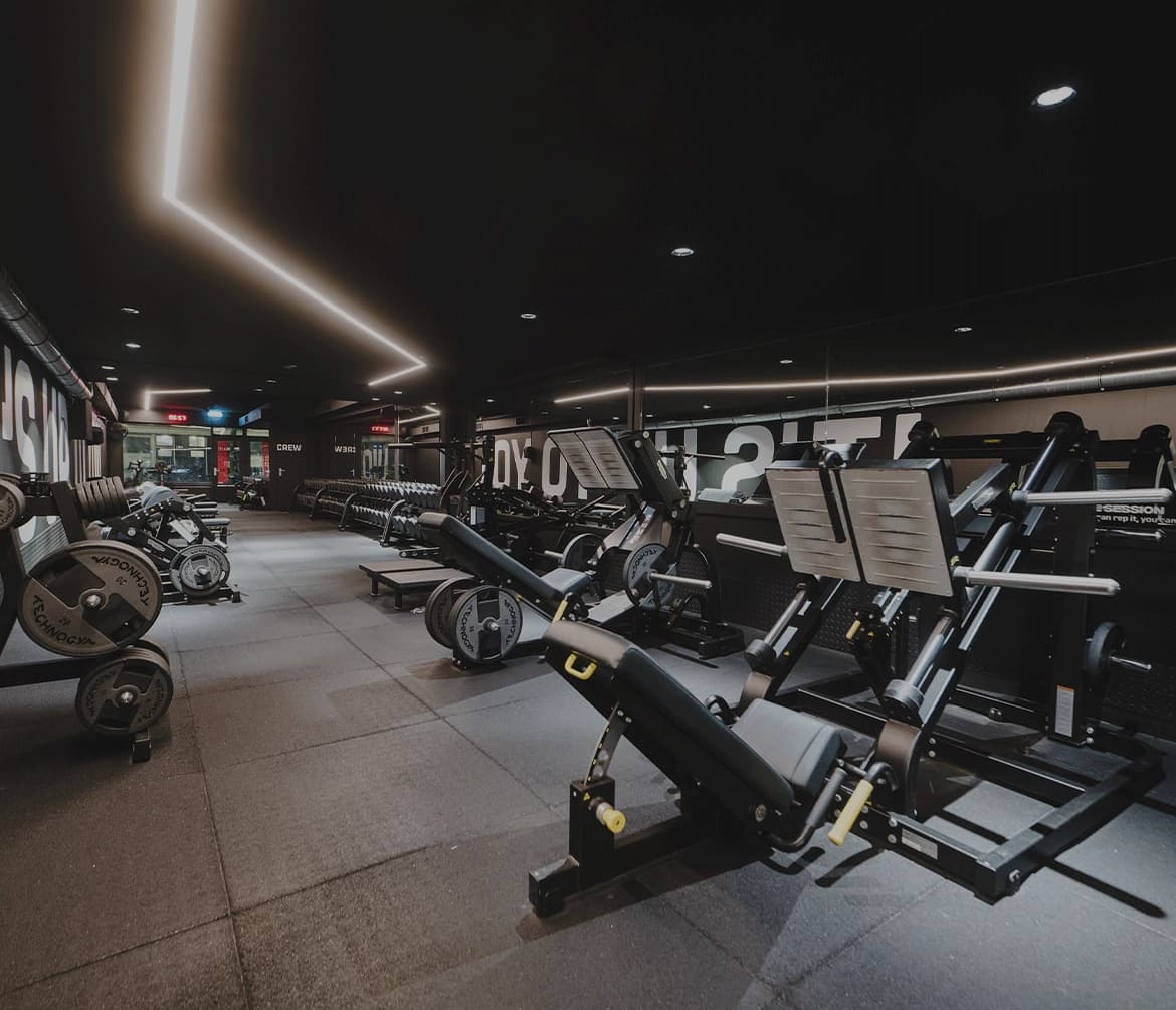 Strength training area with dark finishes and dramatic lighting