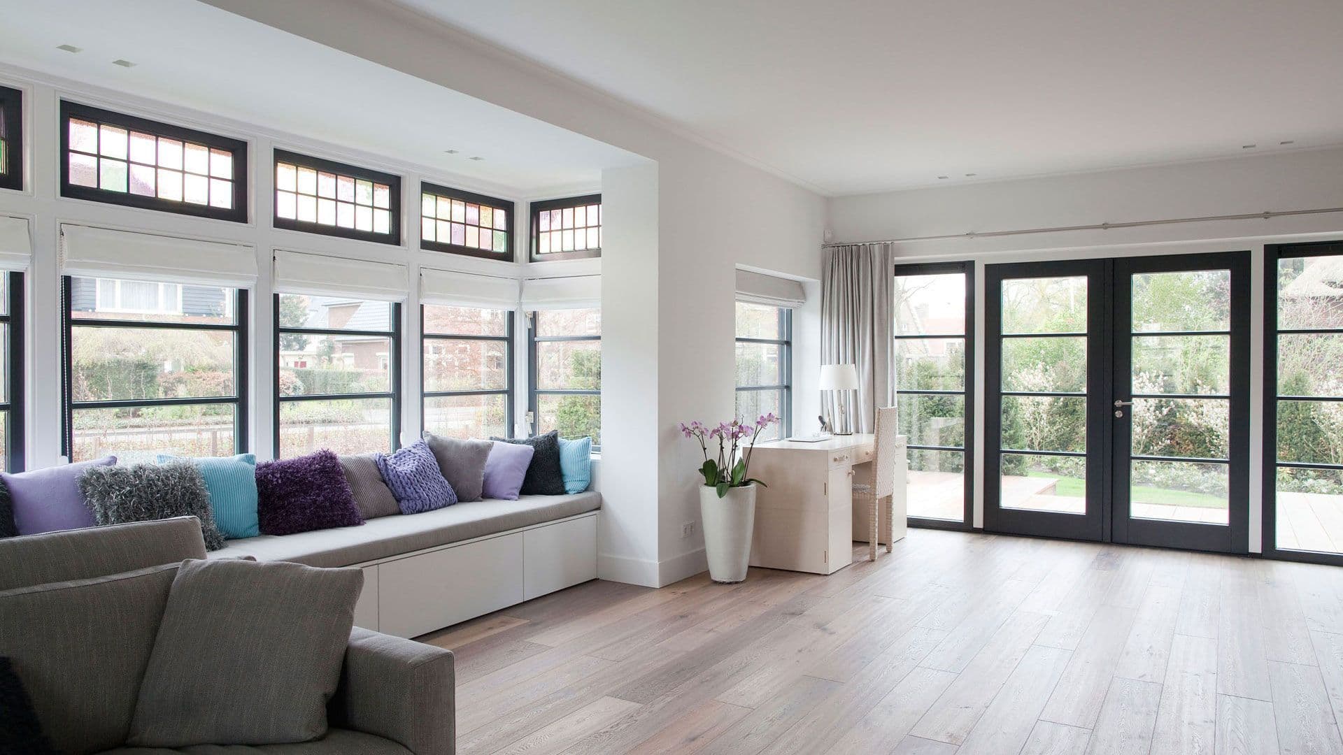 Bright living room with built-in window bench, large windows and garden doors