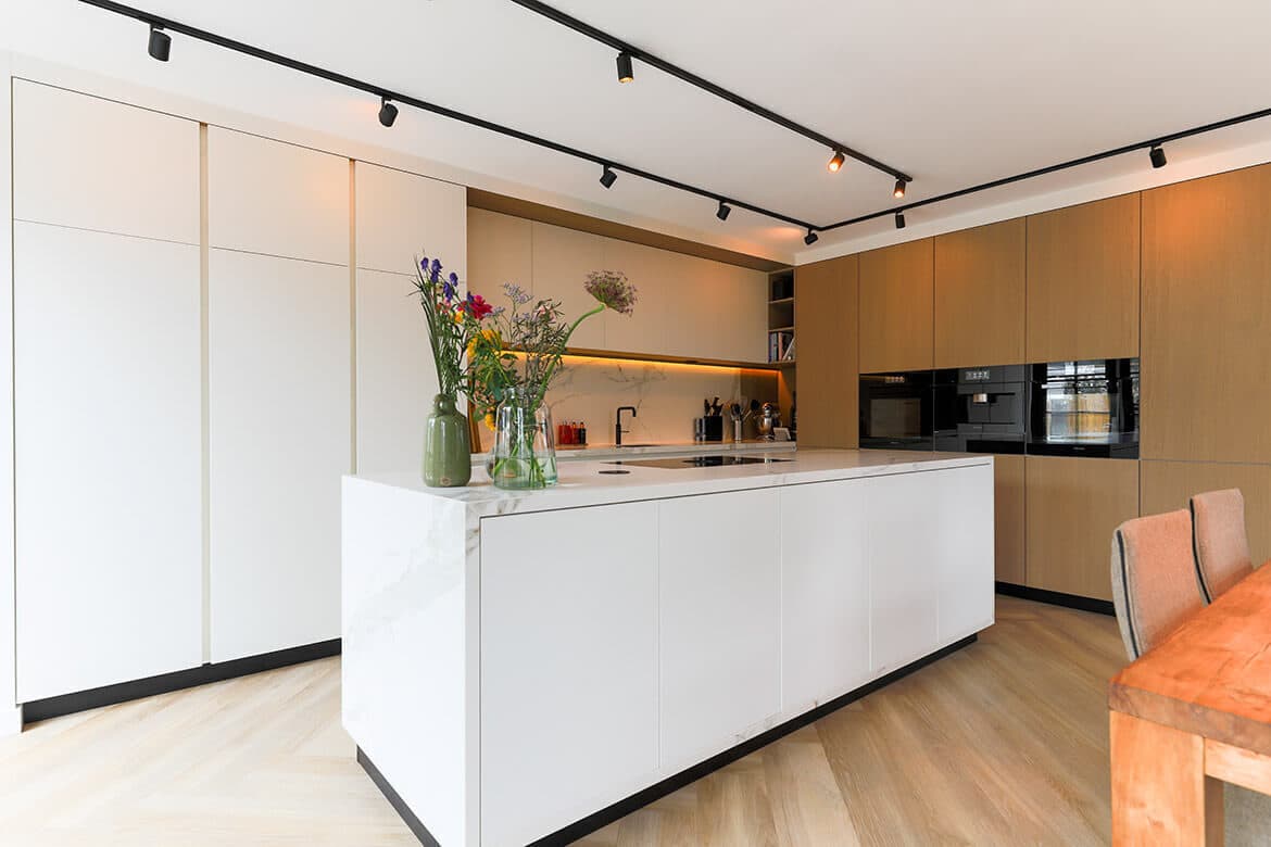 Kitchen with white marble island and natural oak cabinetry